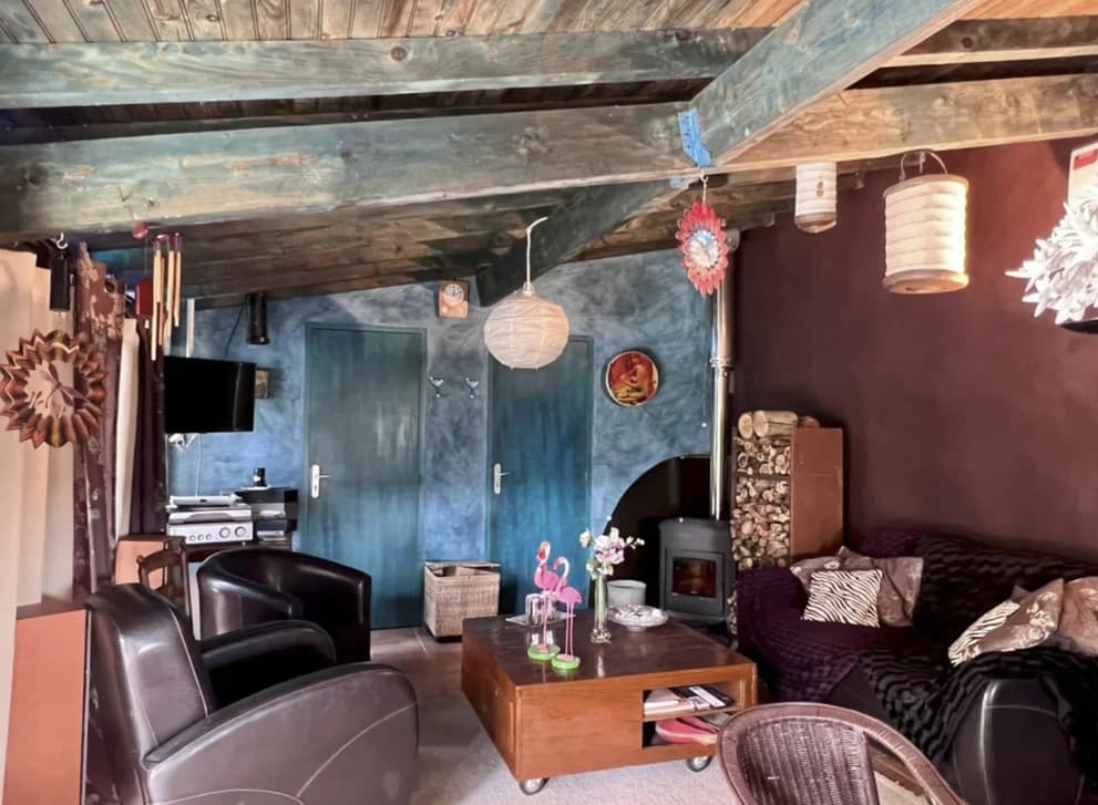 Le salon et ses murs bleu nuit, poêle à bois et lampions