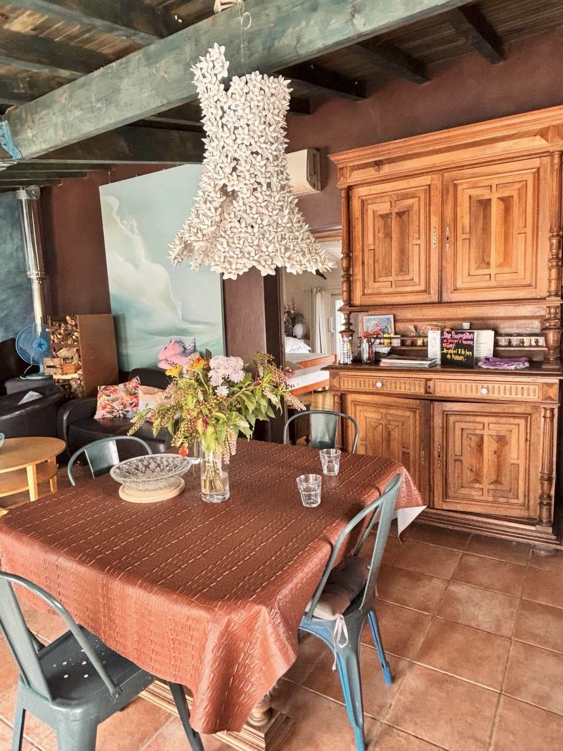 La pièce à vivre, son buffet chiné et son lustre en fleurs de porcelaine